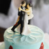 Romantic teal-and-red two-tiered cake with dancing couple topper